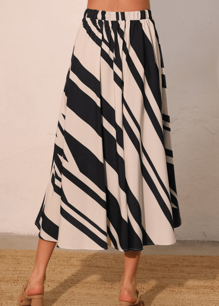 Effortlessly versatile, the Sienna Stripe Midi Swing Skirt delivers timeless appeal with its classic black and ivory vertical stripes. The flowing midi silhouette flatters all body types while the lightweight fabric and elastic waistband ensure comfort from morning through evening. 