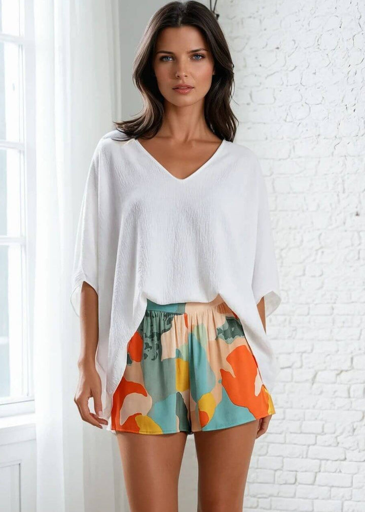 Made in USA, Claire V-Neck Caftan Women's Top in Bright White Paired with Tropical Colors Abstract Print Shorts. 