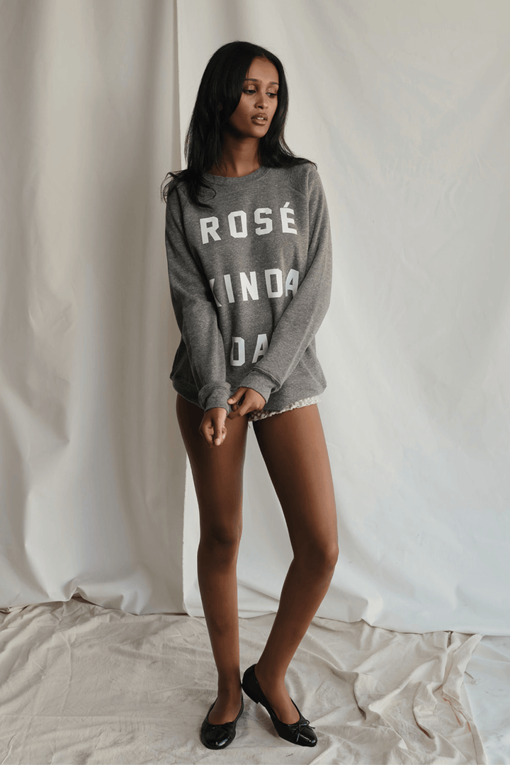 Warning: May induce day-drinking fantasies. This heather grey sweatshirt isn't subtle. Bold white letters scream what you're really thinking: "Rosé Kinda Day." Crafted for comfort with a touch of daring attitude