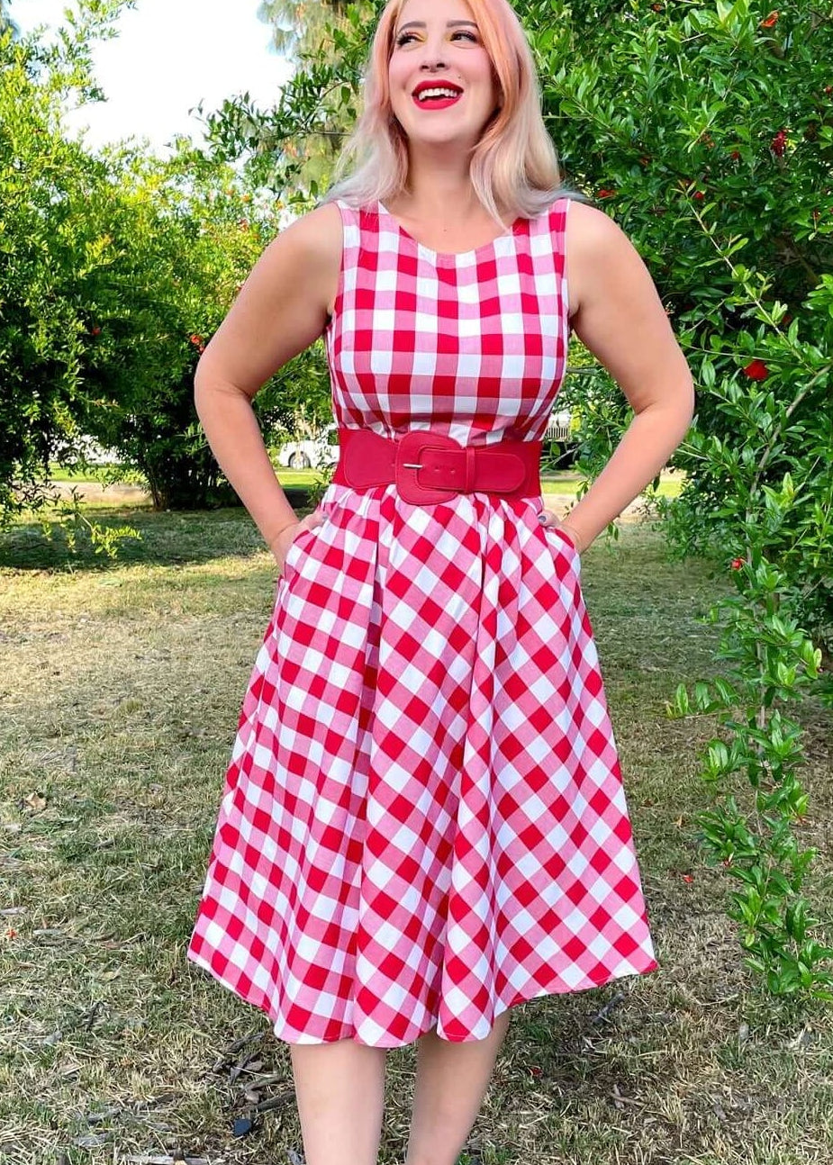Made in USA Women's vintage style piece with fun, modern details; our midi dress is now available in our adorable red gingham. Made from 100% cotton, this classic 1950's inspired dress features a high neckline, longer length swing skirt with hidden side pockets, and back zippered closure.