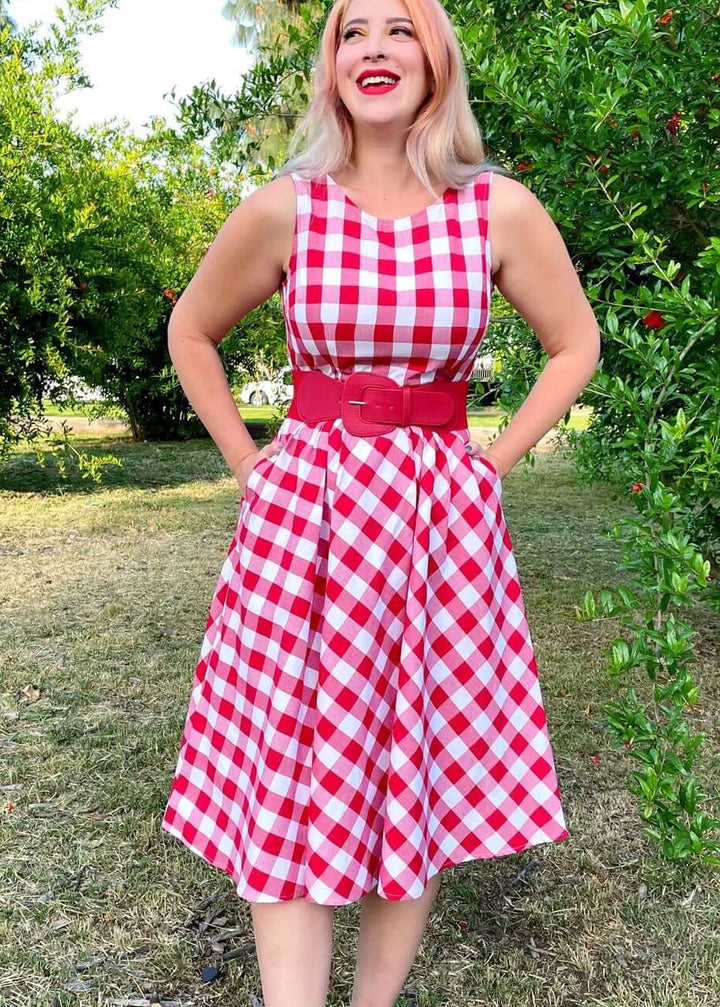 Made in USA Women's vintage style piece with fun, modern details; our midi dress is now available in our adorable red gingham. Made from 100% cotton, this classic 1950's inspired dress features a high neckline, longer length swing skirt with hidden side pockets, and back zippered closure.
