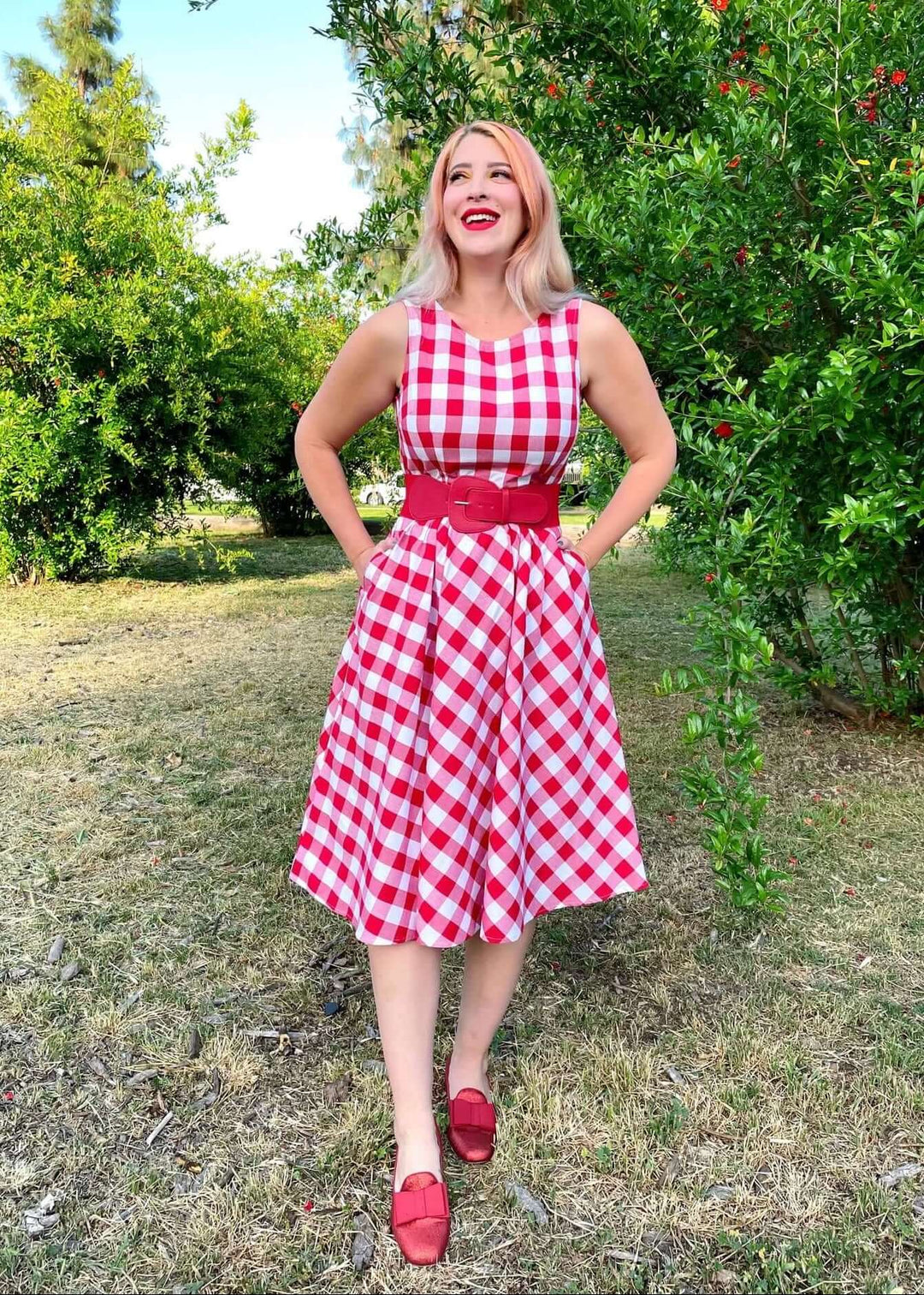 Made in USA Women's vintage style piece with fun, modern details; our midi dress is now available in our adorable red gingham. Made from 100% cotton, this classic 1950's inspired dress features a high neckline, longer length swing skirt with hidden side pockets, and back zippered closure.