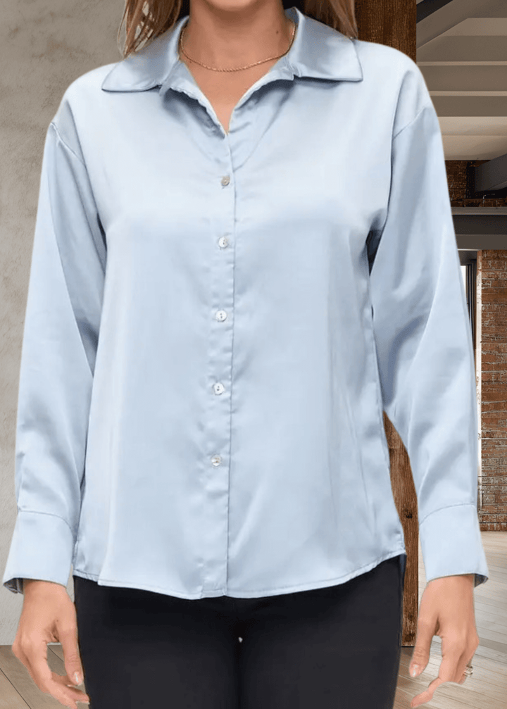 The Laura Satin Button Down Shirt in Steele Blue offers a refined blend of style and comfort. Made in the USA with 97% polyester and 3% spandex, this satin shirt features long sleeves, a classic collar, and a button-front closure for a polished look | Renee C. Style 5177TPA