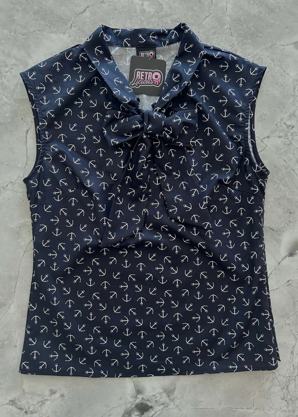 This women's navy nautical theme made in USA top is for the vintage lover at heart! Shown in our Anchor print, this 100% cotton top features bust darts for a flattering silhouette, a side zippered closure for ease of wear, and an oversized bow at the neckline for that perfect 1950's inspired look. 