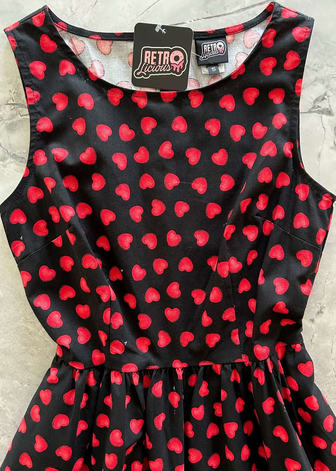 Made in USA, A women's vintage style piece with fun, modern details; our midi dress is now available in our Hearts print. Made from 100% cotton, this classic 1950's inspired dress features a high neckline, longer length swing skirt with hidden side pockets, and back zippered closure. 