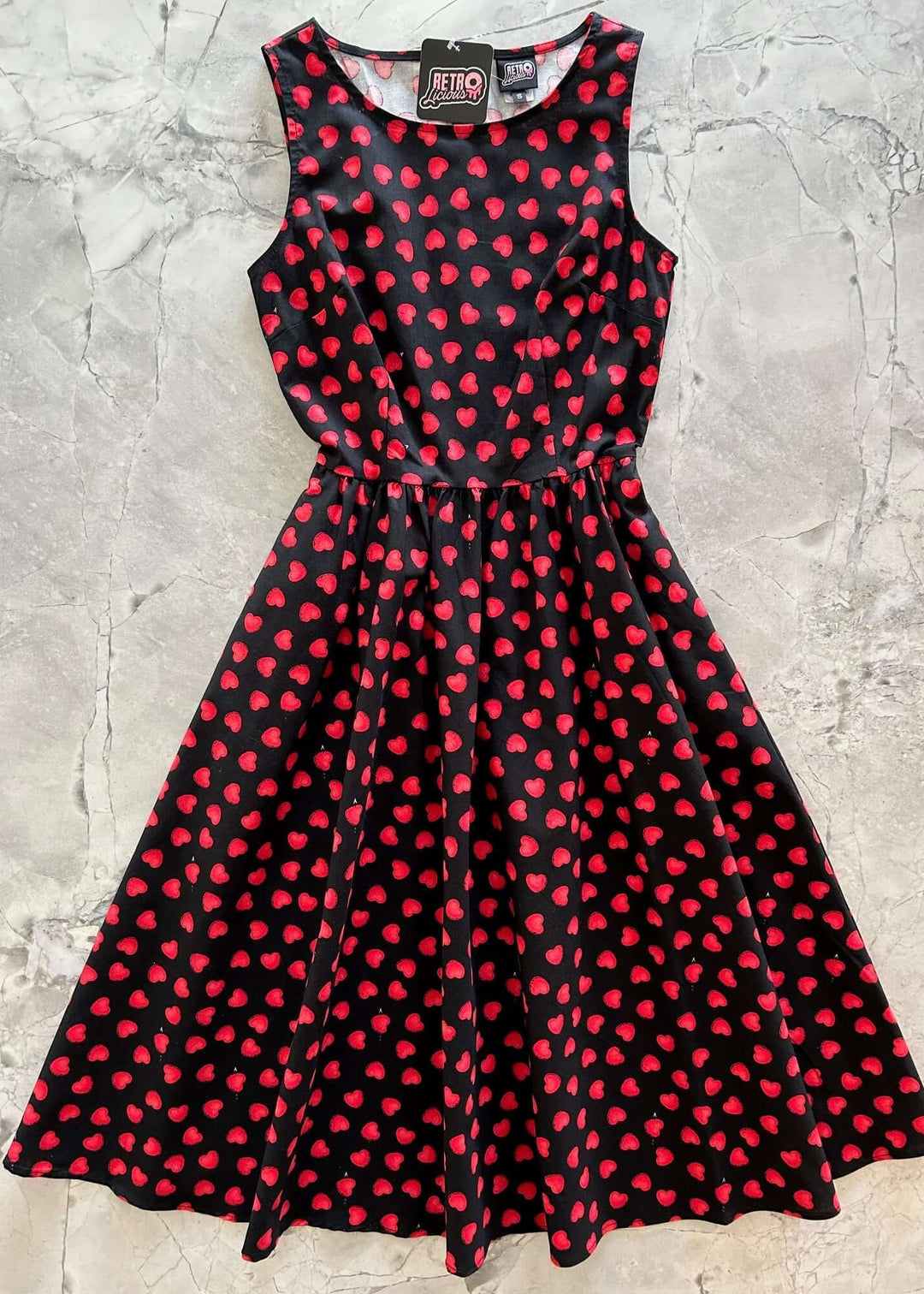 Made in USA, A women's vintage style piece with fun, modern details; our midi dress is now available in our Hearts print. Made from 100% cotton, this classic 1950's inspired dress features a high neckline, longer length swing skirt with hidden side pockets, and back zippered closure. 
