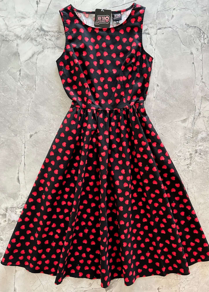 Made in USA, A women's vintage style piece with fun, modern details; our midi dress is now available in our Hearts print. Made from 100% cotton, this classic 1950's inspired dress features a high neckline, longer length swing skirt with hidden side pockets, and back zippered closure. 