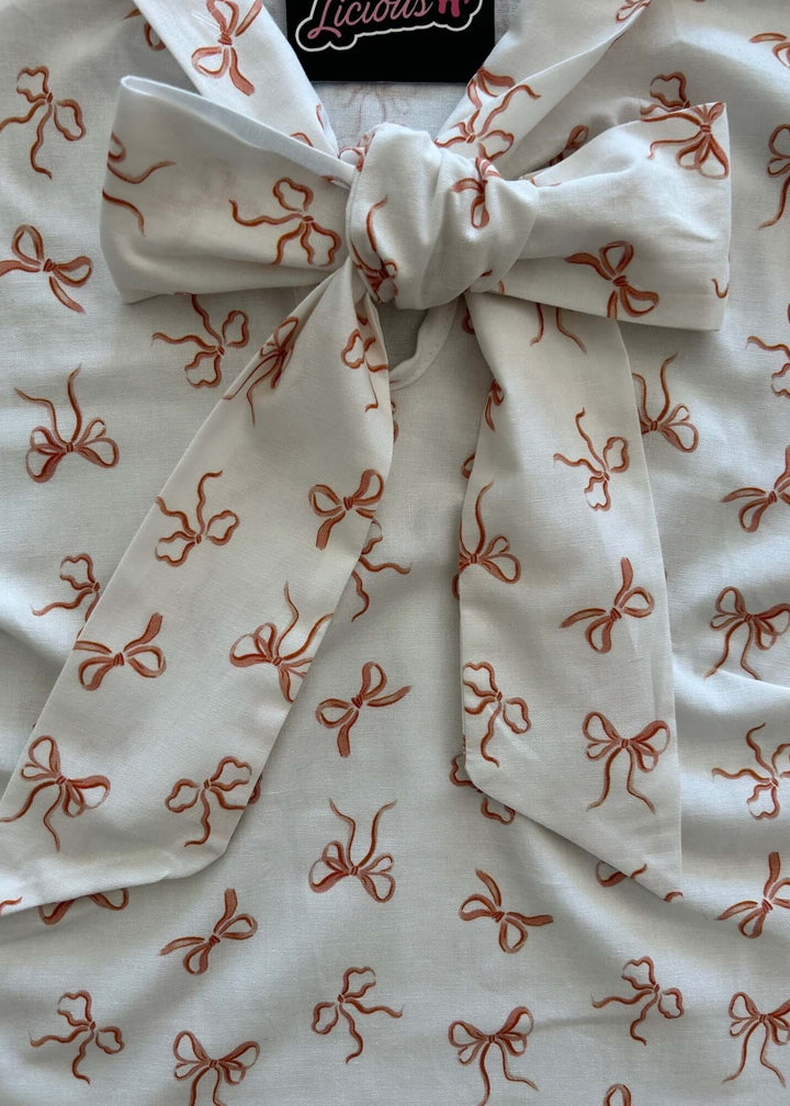 Vintage Style Tops This top is for the vintage lover at heart! Now available in our Pink Bows print. This 100% cotton top features bust darts for a flattering silhouette, a side zippered closure for ease of wear, and an oversized bow at the neckline for that perfect 1950's inspired look.