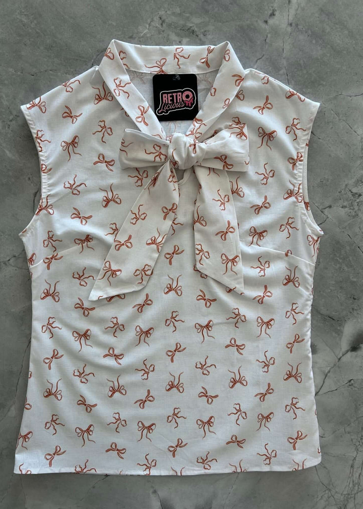 Vintage Style Tops This top is for the vintage lover at heart! Now available in our Pink Bows print. This 100% cotton top features bust darts for a flattering silhouette, a side zippered closure for ease of wear, and an oversized bow at the neckline for that perfect 1950's inspired look.