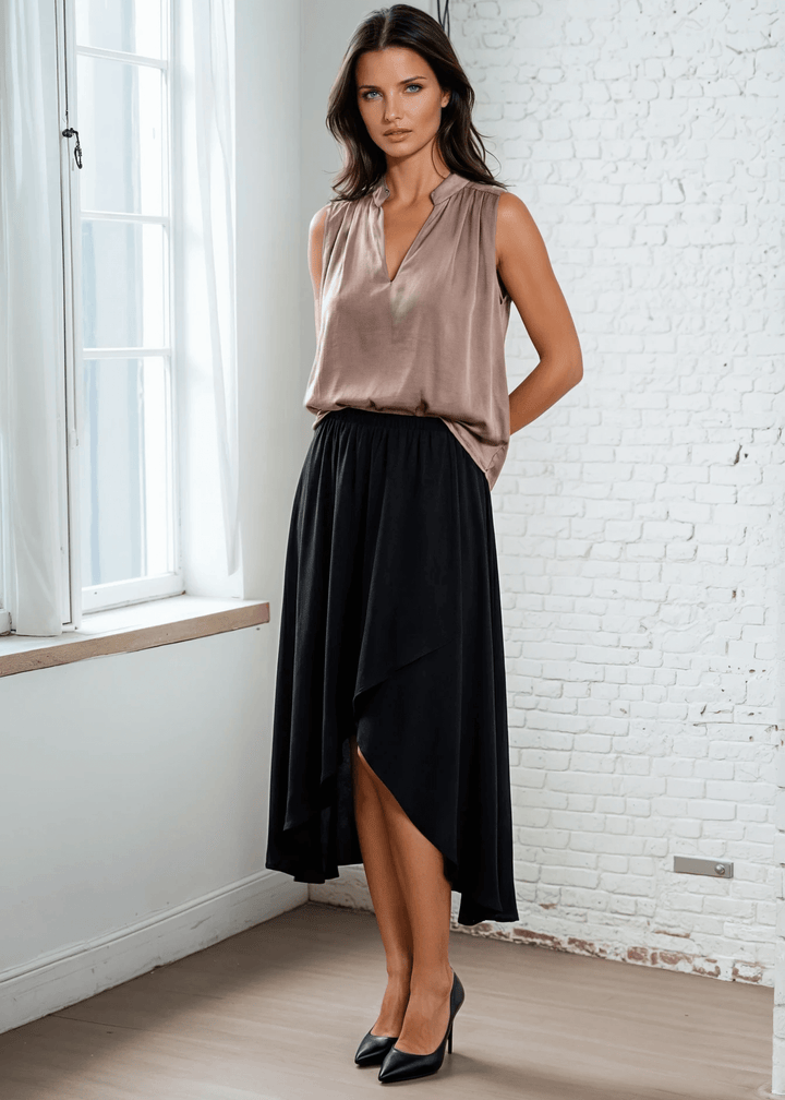Elevate your wardrobe with this sophisticated taupe poly silk top, designed for effortless elegance. The sleeveless silhouette and flattering V-neckline create a refined look, while strategic pleating at the front and back adds subtle dimension and movement. 