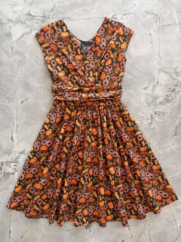 Made in USA by Retrolicious, 100% cotton Greta dress with a V-neck, gathered waist, pockets, and a playful pumpkin-floral print. Sizes XS–4X.