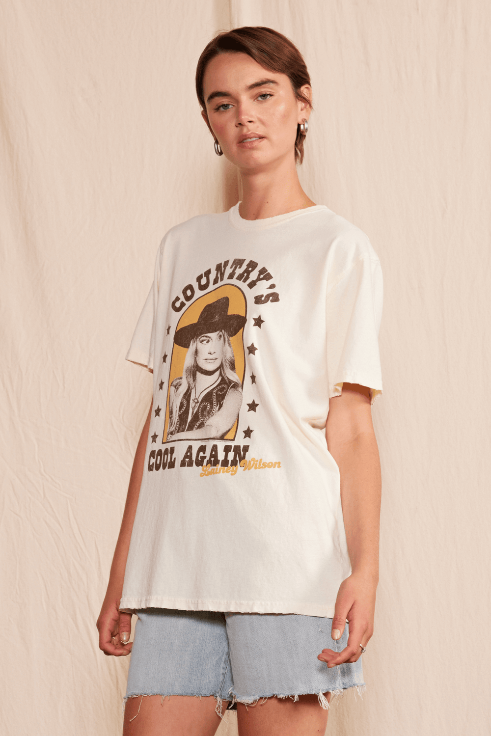 Get ready to cool down this summer with the Lainey Wilson Country's Cool Again Tee. Made from 100% organic cotton, this unisex crew neck tee will have you feeling comfortable and stylish. The tee boasts a playful cowboy style, perfect for any country music fan. Made in USA