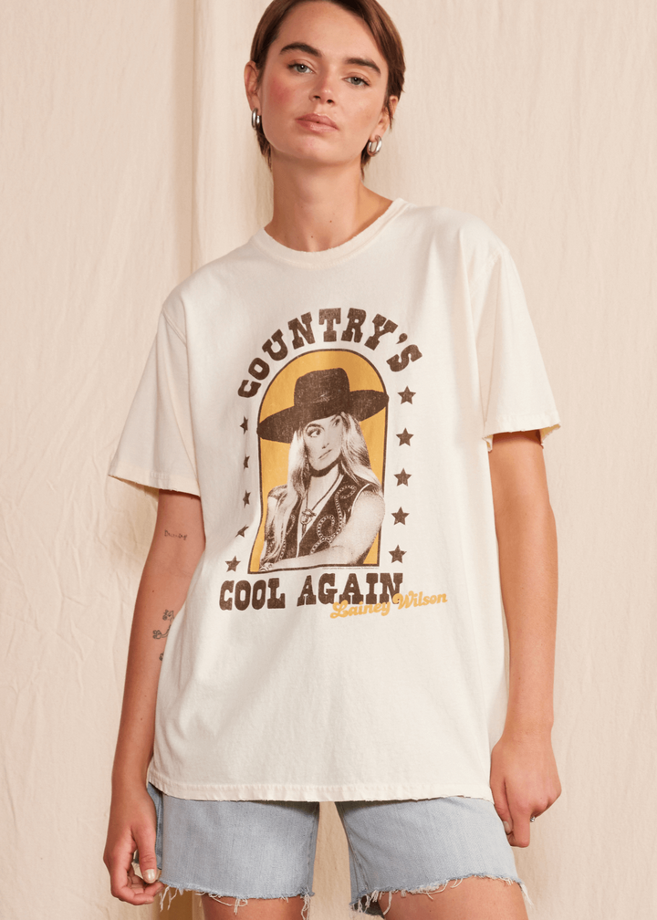 Get ready to cool down this summer with the Lainey Wilson Country's Cool Again Tee. Made from 100% organic cotton, this unisex crew neck tee will have you feeling comfortable and stylish. The tee boasts a playful cowboy style, perfect for any country music fan. Made in USA