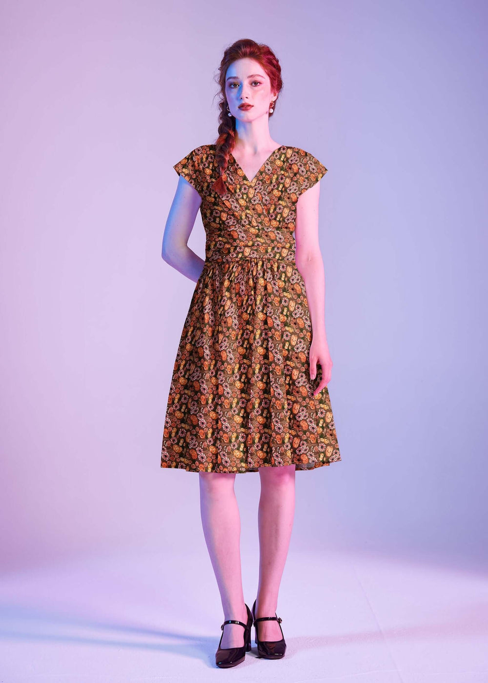 Made in USA by Retrolicious, 100% cotton Greta dress with a V-neck, gathered waist, pockets, and a playful pumpkin-floral print. Sizes XS–4X.