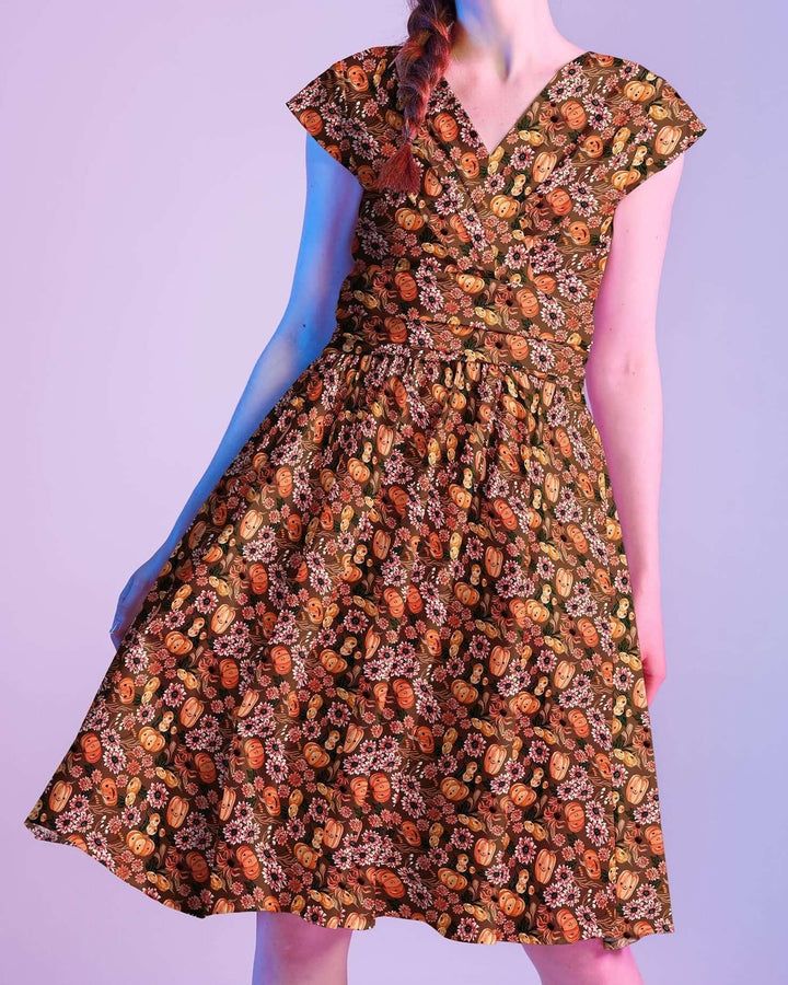 Made in USA by Retrolicious, 100% cotton Greta dress with a V-neck, gathered waist, pockets, and a playful pumpkin-floral print. Sizes XS–4X.