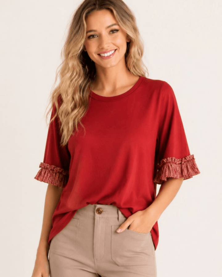 Made in USA Rae ruffle contrast sleeve top in rust, flowy solid knit with half-length ruffle sleeves, front view with tan trousers