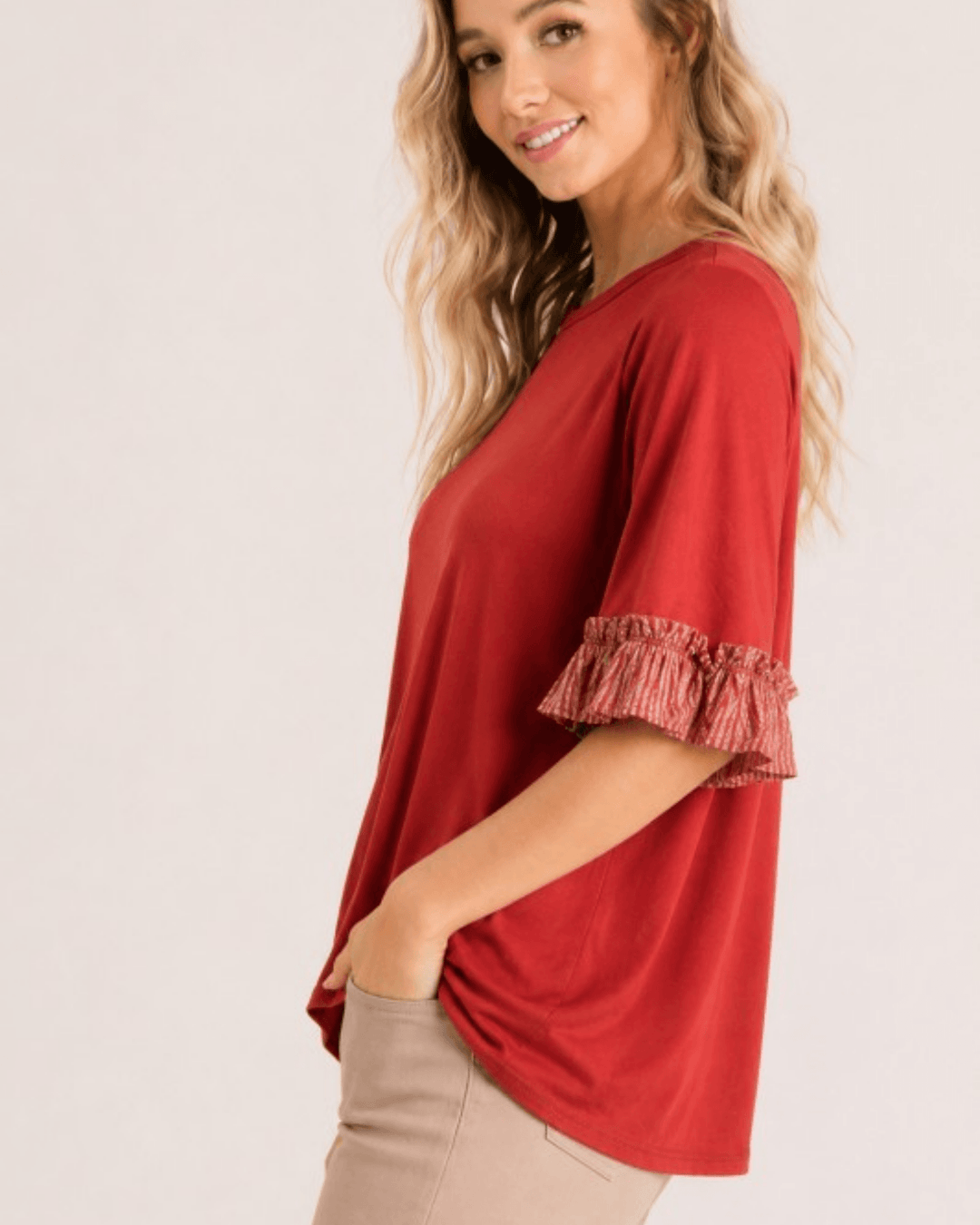 Made in USA rust flowy knit top with printed contrast ruffle sleeve, side view