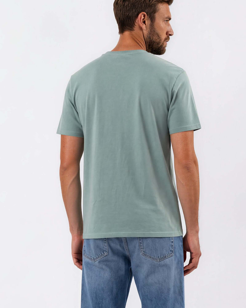 Made in USA Vintage Pigment Dyed Softest Tee - Fern: back view of sage green short sleeve tee on male model with jeans