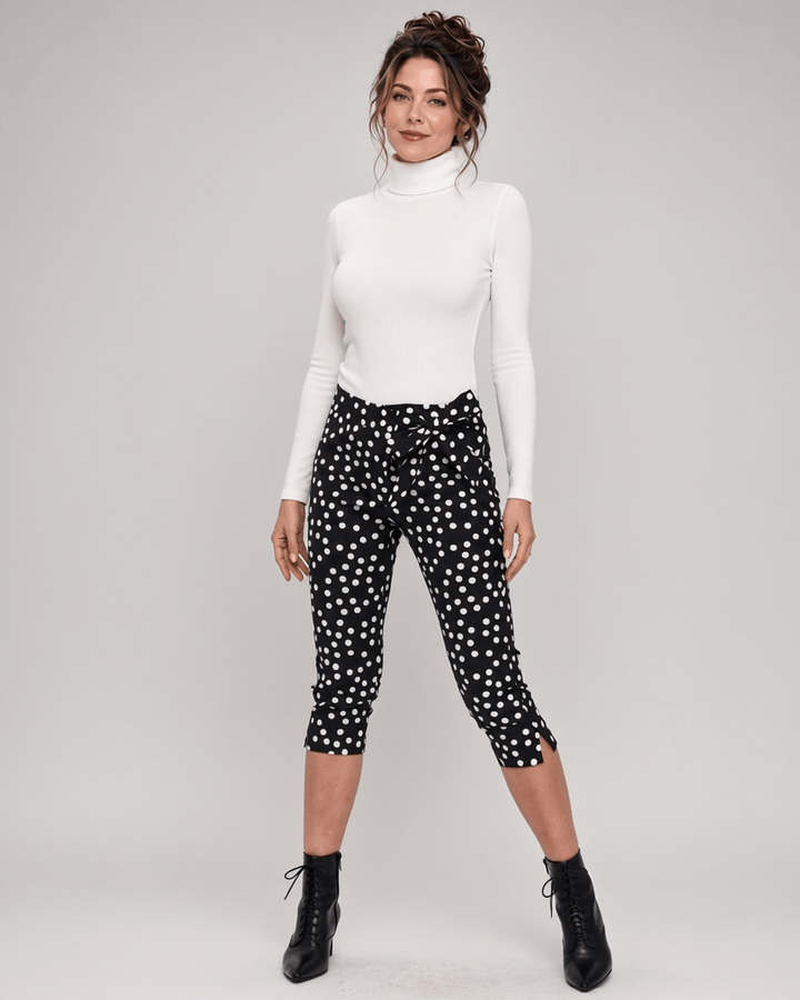 Made in USA. Polly black and white polka dot capri pants feature cotton-rich stretch, a bow waist tie and side-slit hems. A playful statement pair! Style 5460PT by Renee C