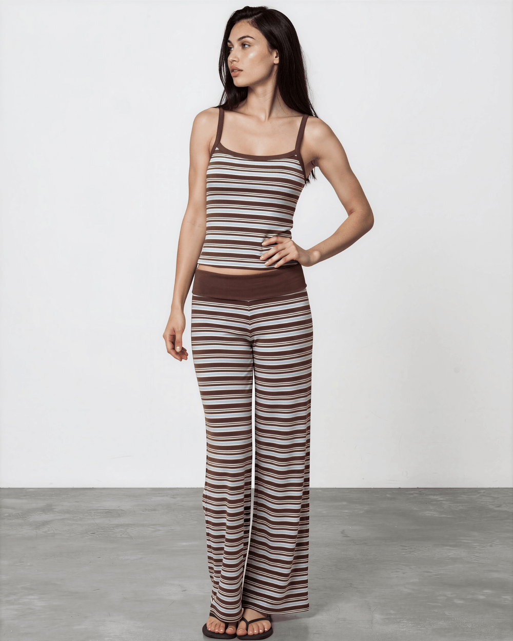 woman wearing Made in USA women's striped pajama set with a fitted tank, fold-over waistband, and relaxed wide-leg pants in brown, blue, and white. Super soft and stretchy fabric.