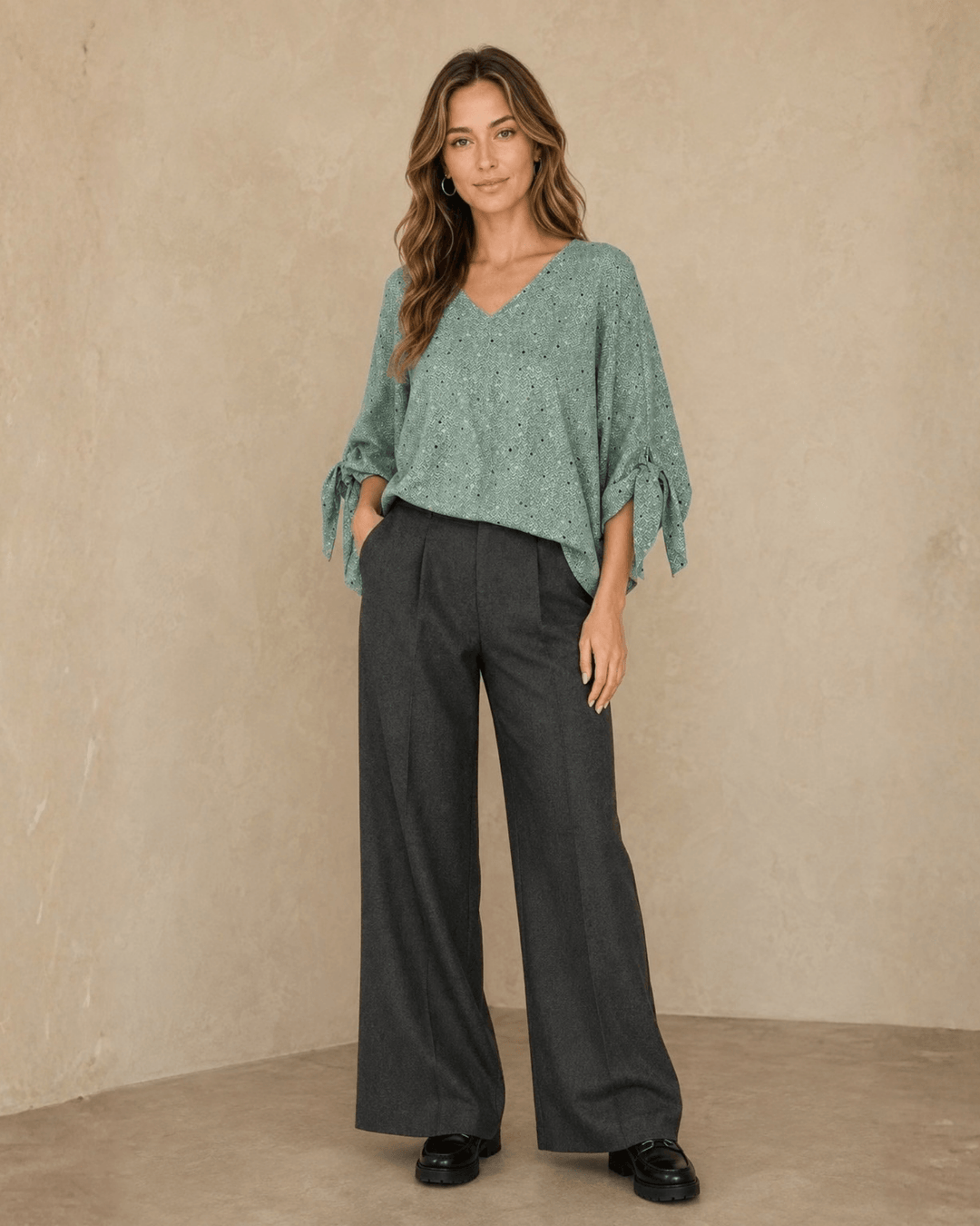Made in USA. Green confetti dot chevron blouse with a V-neck, dolman sleeves and adjustable cuff ties. Lightweight woven fabric with a loose, flowing fit.