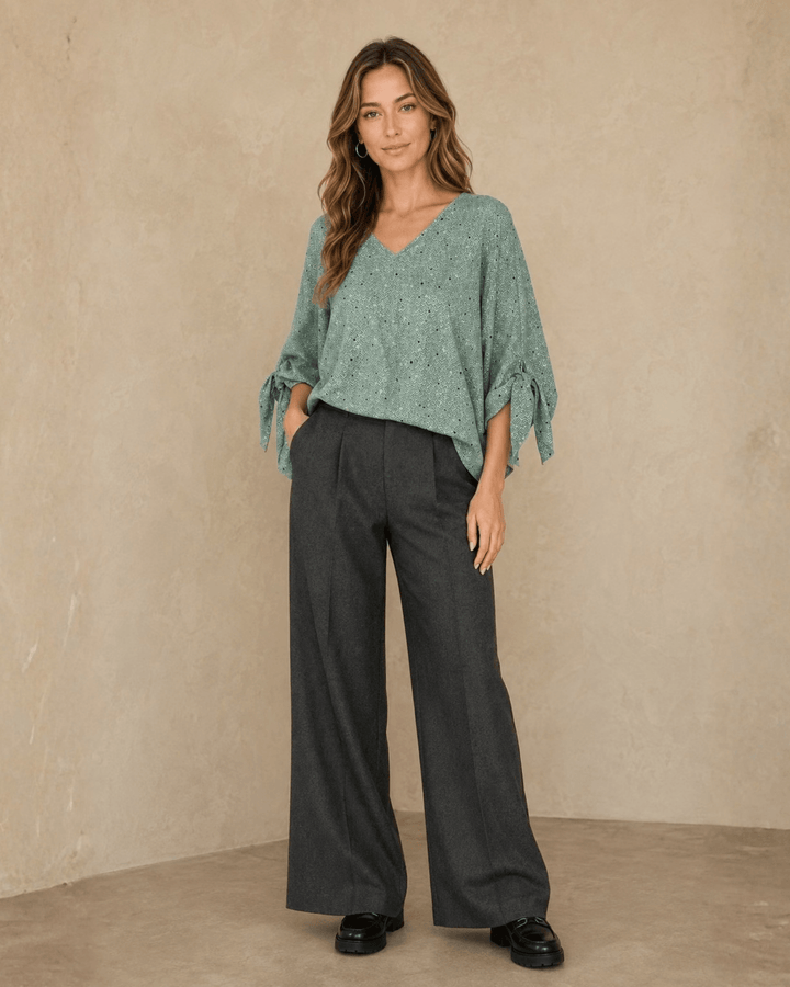 Made in USA. Green confetti dot chevron blouse with a V-neck, dolman sleeves and adjustable cuff ties. Lightweight woven fabric with a loose, flowing fit.