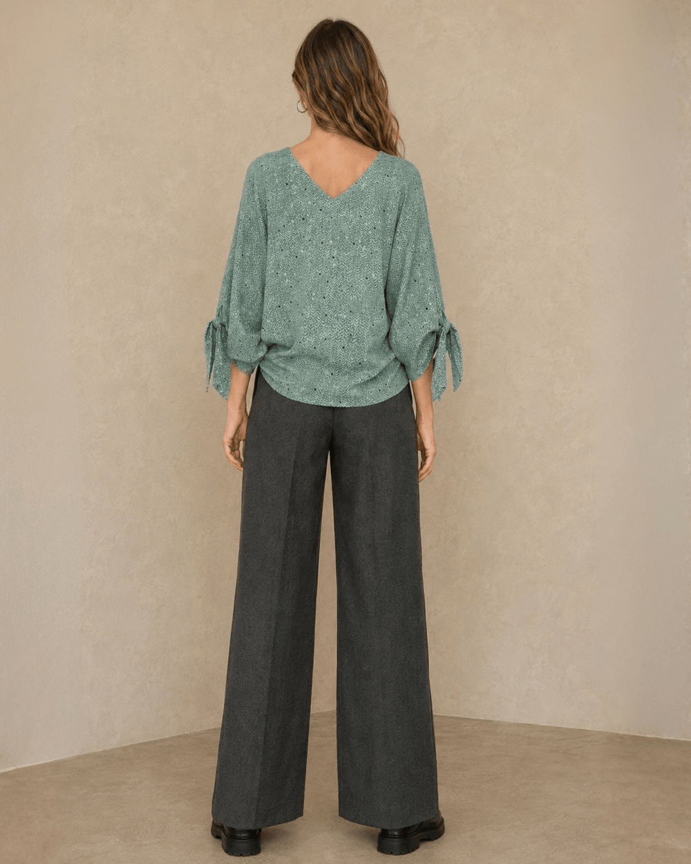 Made in USA. Green confetti dot chevron blouse with a V-neck, dolman sleeves and adjustable cuff ties. Lightweight woven fabric with a loose, flowing fit.