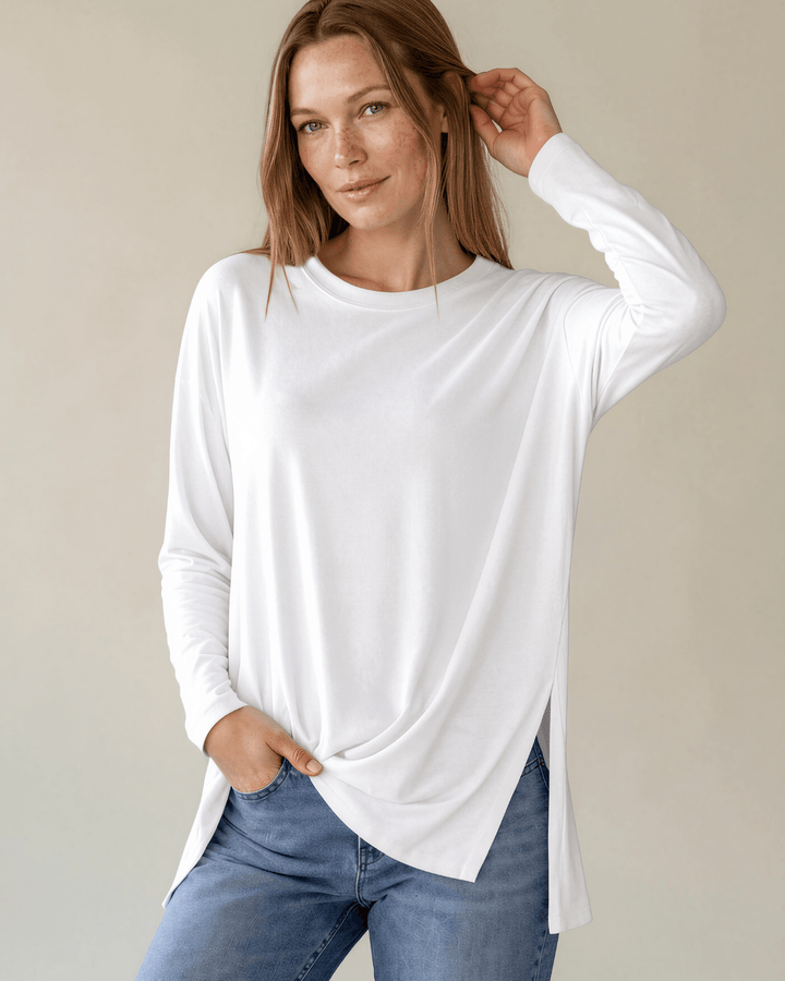 Made in USA. White long sleeve cotton top with a crew neck, relaxed fit and side slits. Soft 95% cotton with stretch for easy everyday layering.