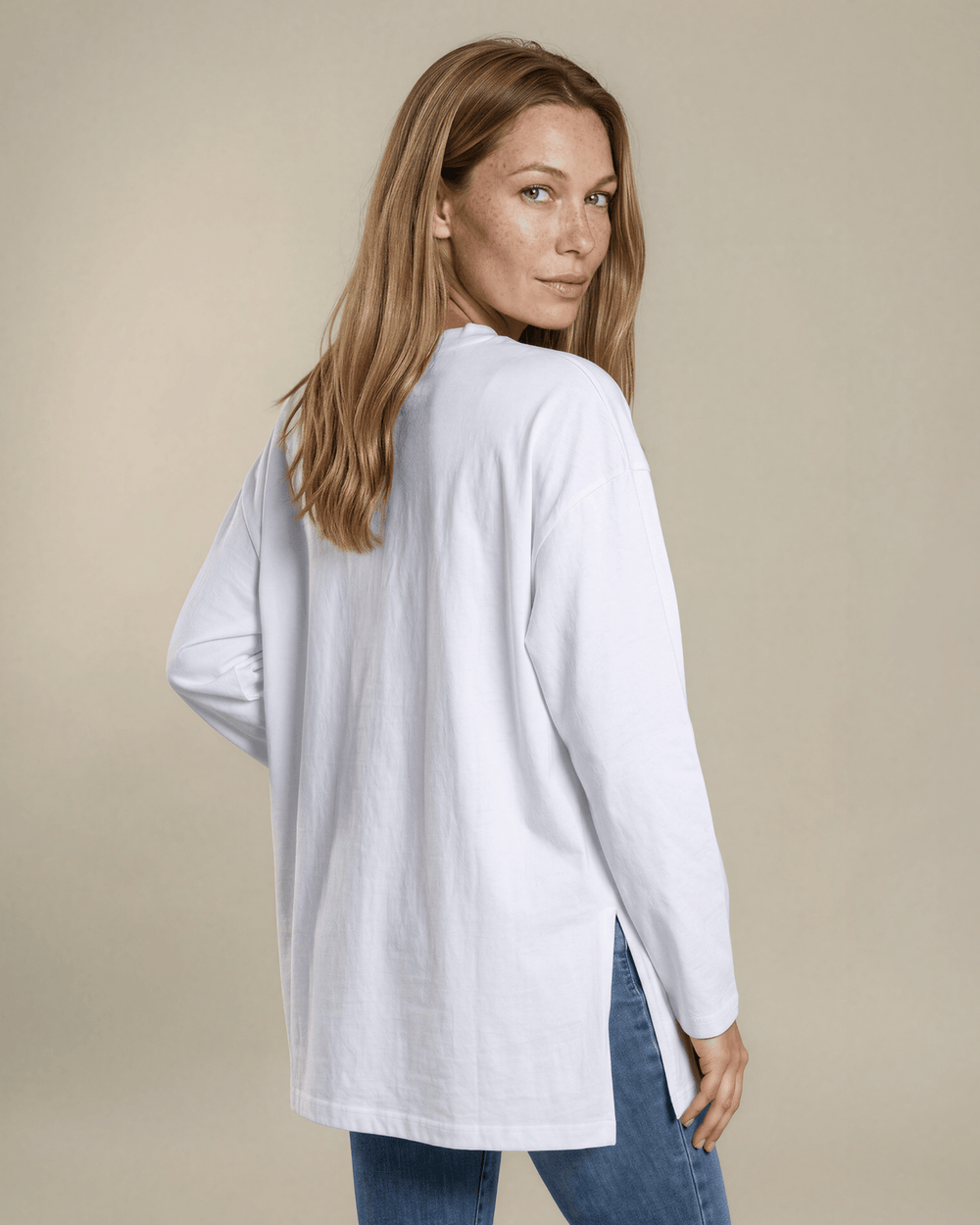 Made in USA. White long sleeve cotton top with a crew neck, relaxed fit and side slits. Soft 95% cotton with stretch for easy everyday layering.