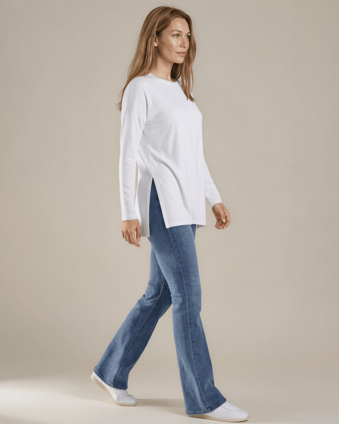 Made in USA. White long sleeve cotton top with a crew neck, relaxed fit and side slits. Soft 95% cotton with stretch for easy everyday layering.