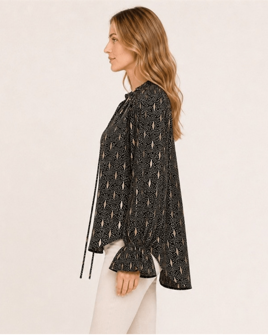 Made in USA Radiant Ruffle Neck Foil Print Blouse - Black: side profile showing high-low hem and sleeve ties