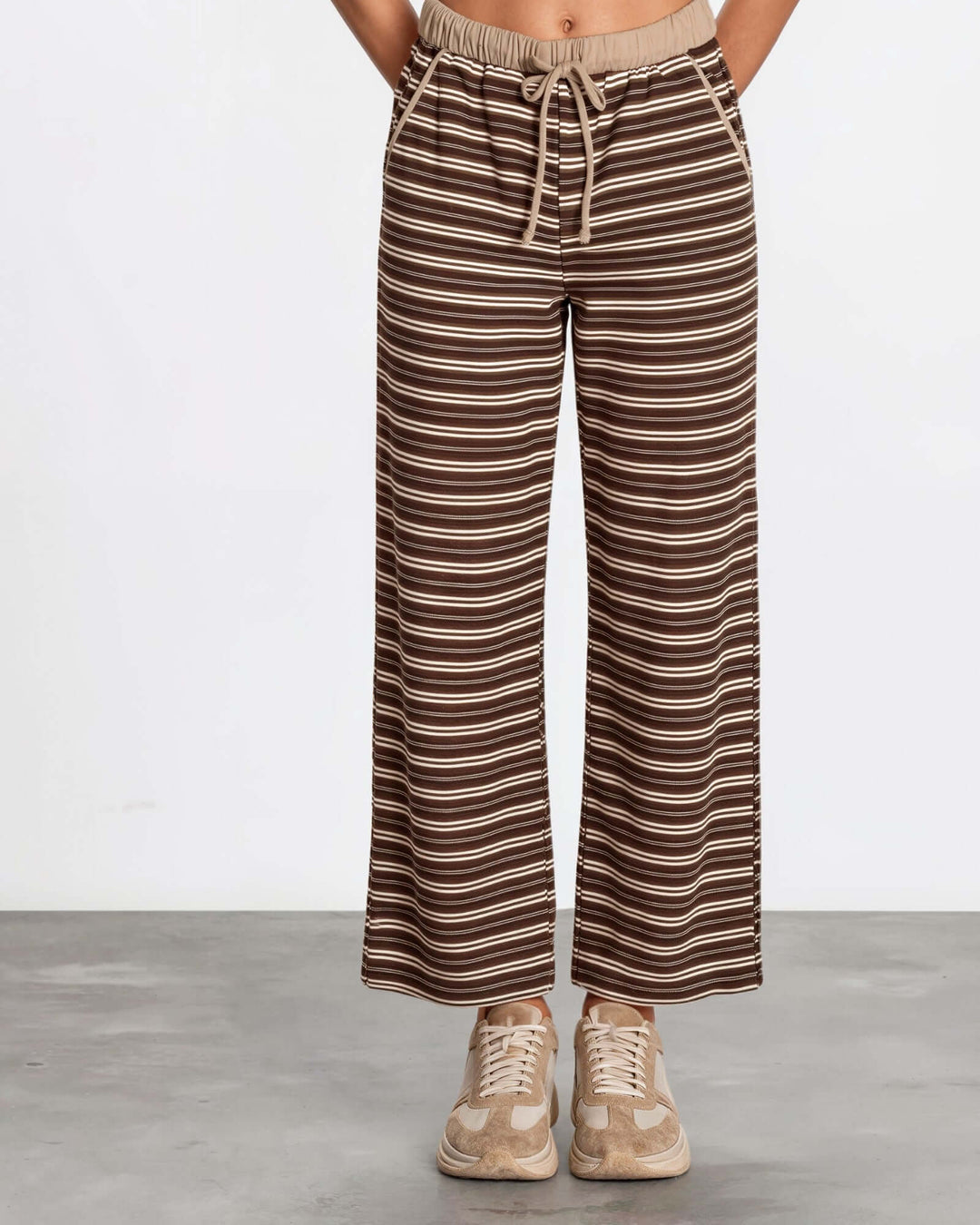 Made in USA women's brown and taupe striped wide leg ankle length drawstring lounge pants with side pockets, styled with a holiday graphic sweatshirt