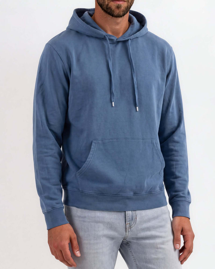 Made in USA vintage pigment dyed fleece pullover hoodie in Blue Steel with drawstring hood, front pouch pocket, and ribbed cuffs and hem