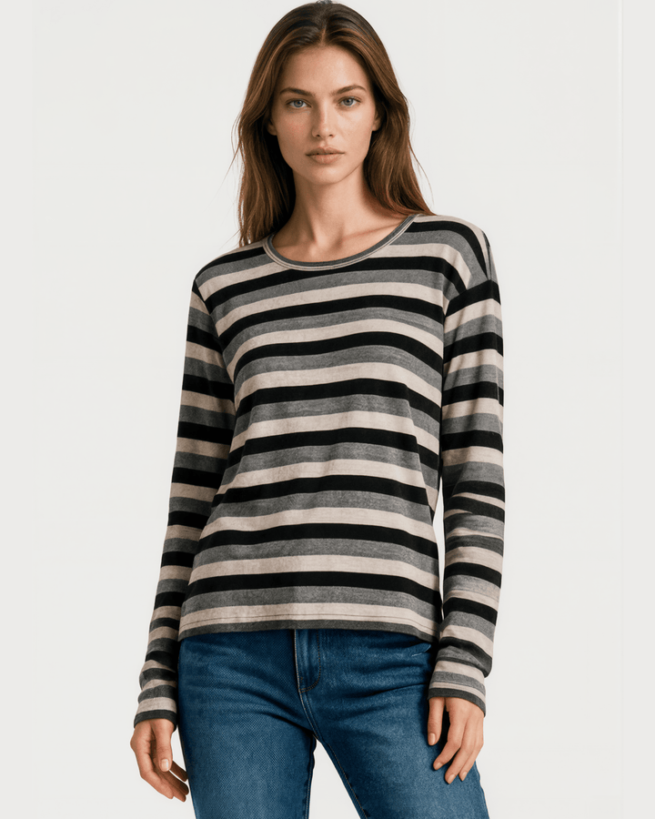 Made in USA Stella women’s grey, black, and cream striped long sleeve top with a round neckline, dropped shoulders, relaxed oversized fit, and rounded hem.