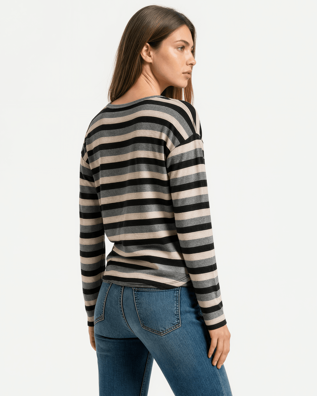 Made in USA Stella women’s grey, black, and cream striped long sleeve top with a round neckline, dropped shoulders, relaxed oversized fit, and rounded hem.