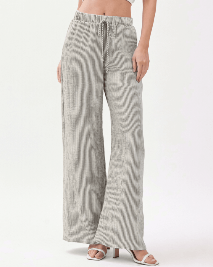 Charcoal and off-white vertical pinstripe seersucker wide leg pants with a soft crinkled texture, elastic drawstring waistband, and side pockets in a relaxed flowy silhouette. Made in USA
