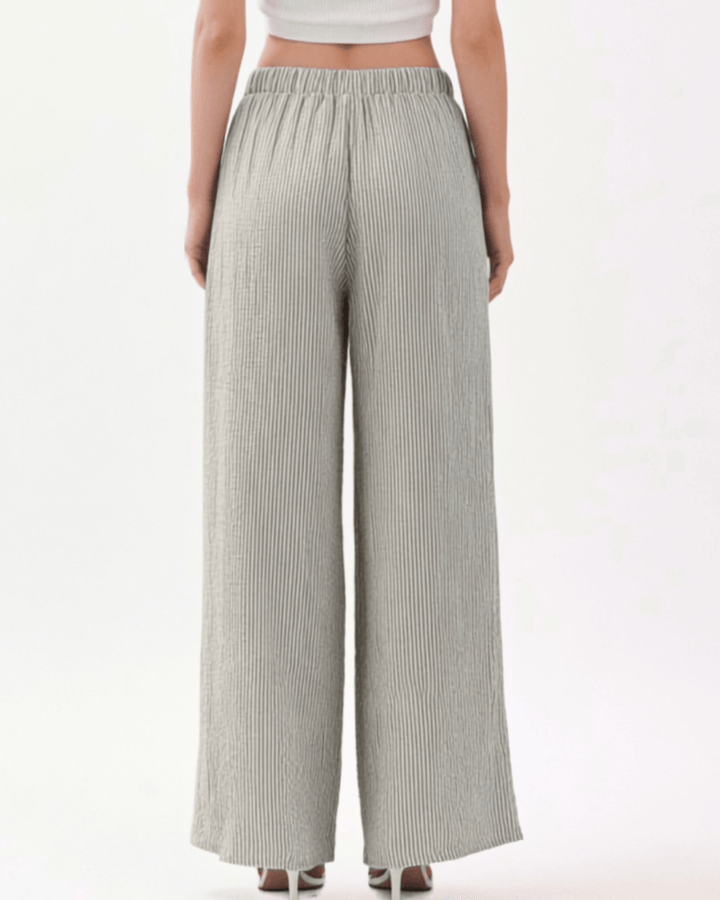 Charcoal and off-white vertical pinstripe seersucker wide leg pants with a soft crinkled texture, elastic drawstring waistband, and side pockets in a relaxed flowy silhouette. Made in USA