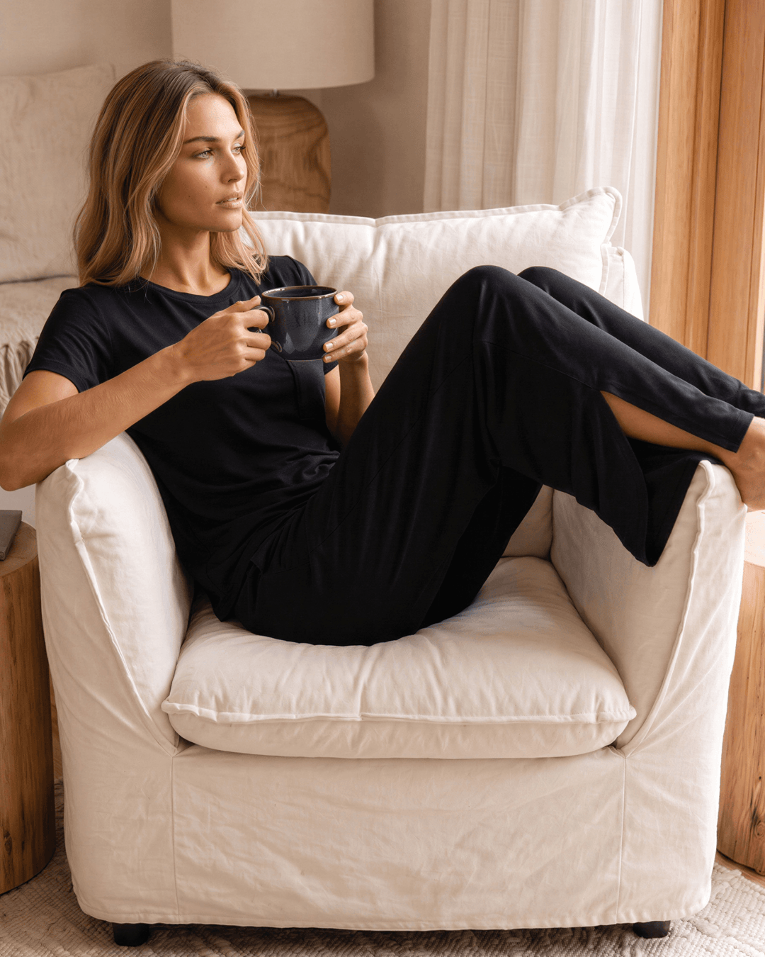 "Black two-piece loungewear set featuring a relaxed-fit short-sleeve crew neck tee with a chest pocket and wide-leg pants with split hems and an elastic waistband, in a soft stretch fabric blend. Made in USA."