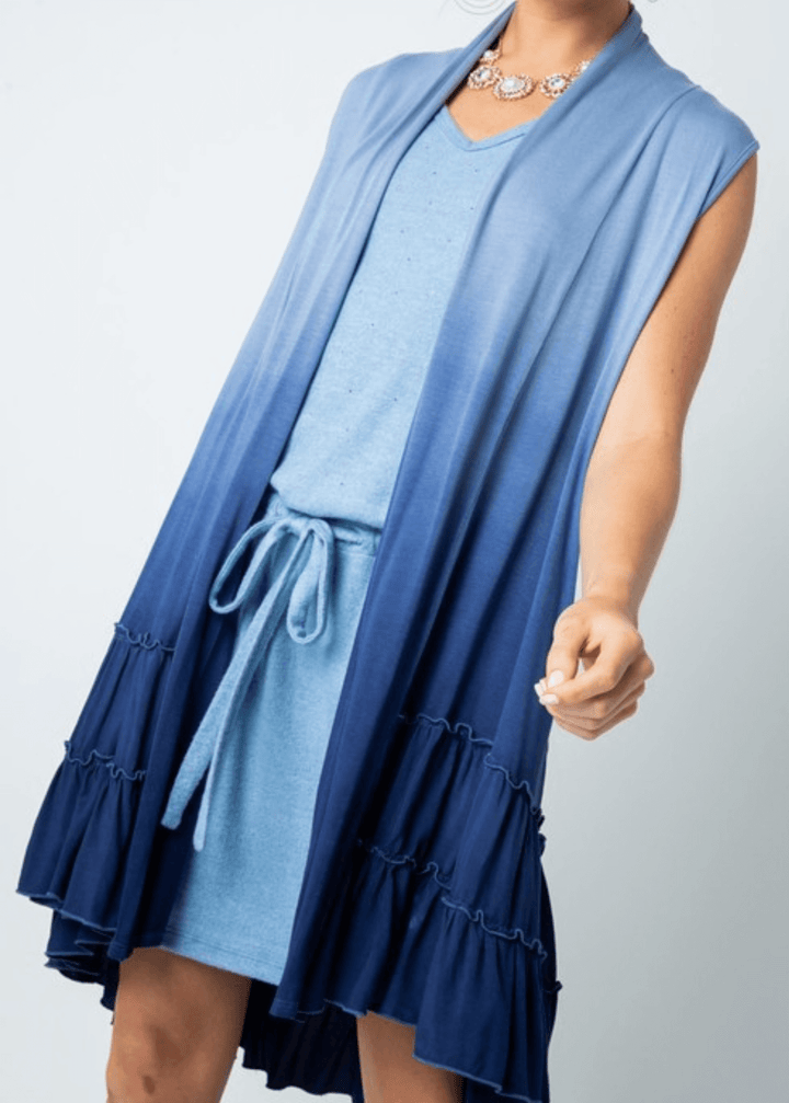 Blue ombre tie-dye meets effortless elegance in this versatile cardigan vest. Featuring a tiered ruffled hem and flowing silhouette, it transitions seamlessly from casual to dressed-up occasions. Crafted from a luxurious viscose-spandex blend for comfort and movement, this Made in USA piece is designed to flatter and inspire. 