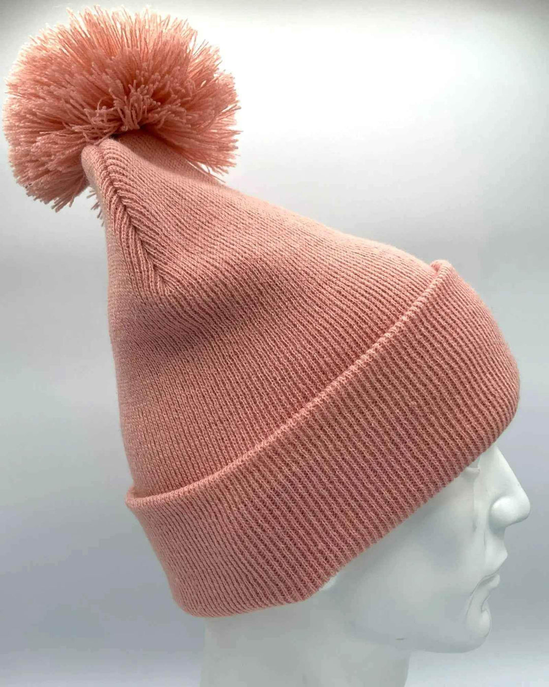 Keep warm and stylish with the HAAKWEAR PomPom Beanie in Pearl Pink, proudly made in the USA. This cozy beanie is perfect for adding a touch of fashion to your winter wardrobe. . Made from 100% Acrylic.