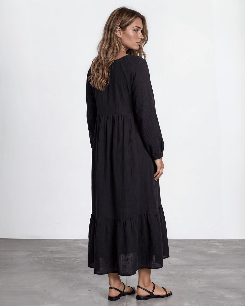 Black Cotton Gauze Maxi Dress. Scoop neck,  empire waist, long billowy sleeves, tiered ruffle hem, 100% cotton. S–XL. Made in USA.