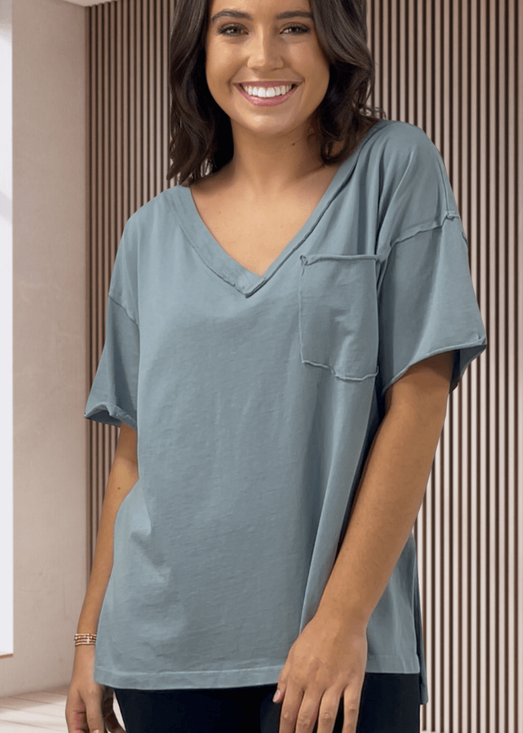 This Made in USA Slate Blue T-Shirt offers a relaxed fit made from soft, 100% cotton medium-weight fabric that is garment washed for lasting comfort. Featuring a raw edge detail and a convenient front pocket, this short-sleeve tee is perfect for everyday wear.