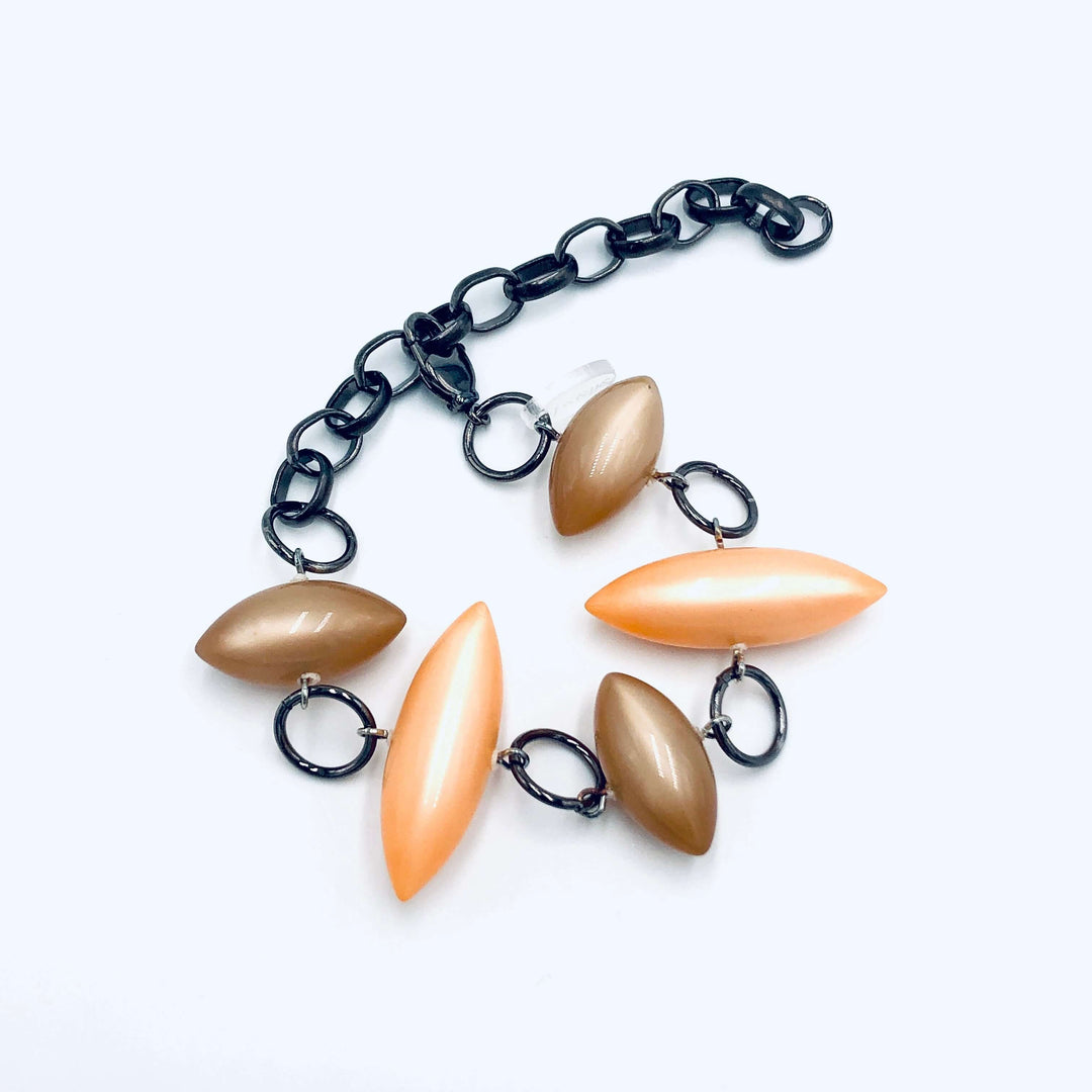 Moonglow pod station bracelet in tangerine & champagne. Vintage 1960s Lucite, adjustable 6.5"-10", hypoallergenic. Stackable, made in USA.