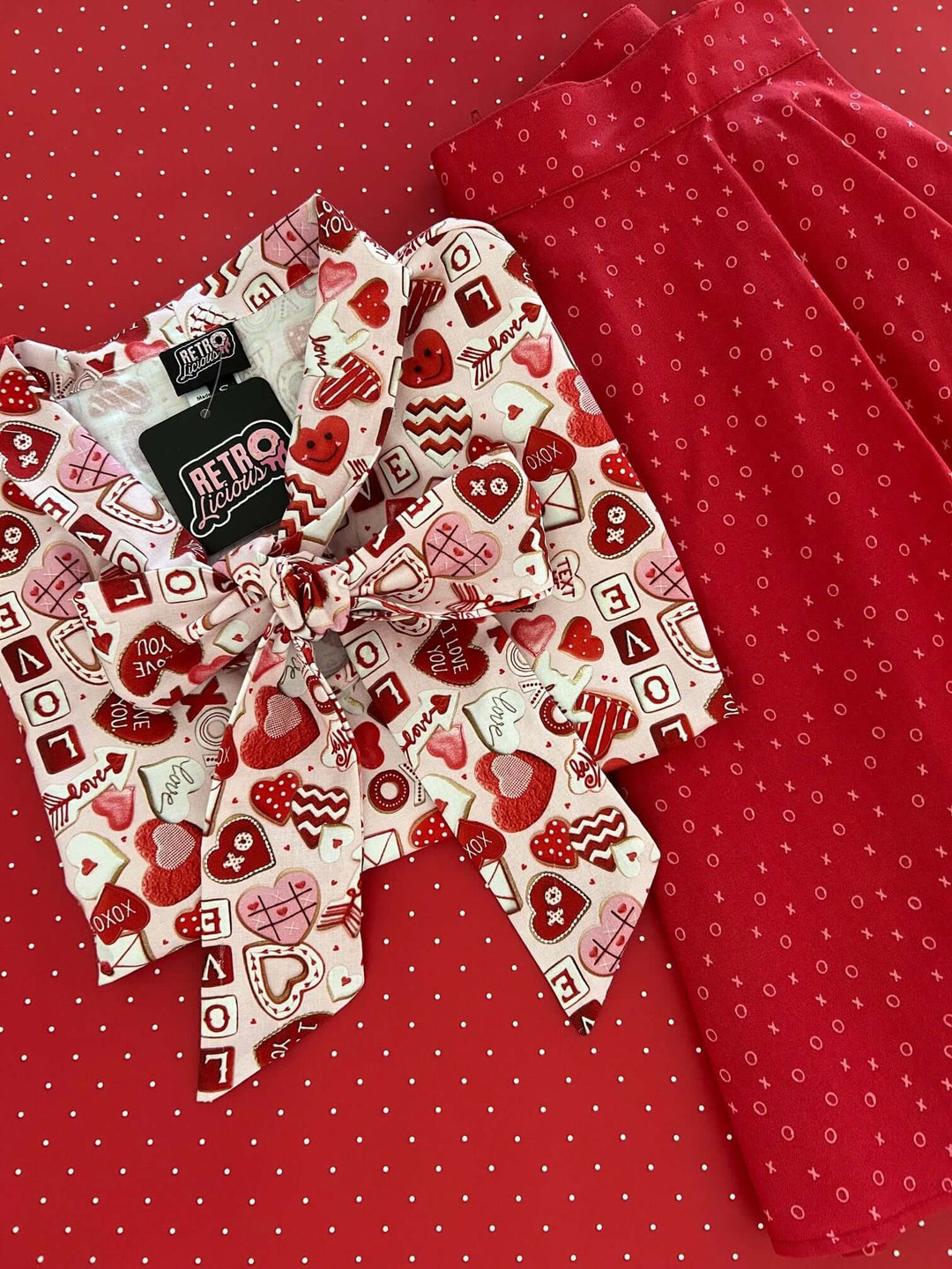 Vintage Tops This top is for the vintage lover at heart! Shown in our XOXO print, this 100% cotton top features bust darts for a flattering silhouette, a side zippered closure for ease of wear, and an oversized bow at the neckline for that perfect 1950's inspired look.
