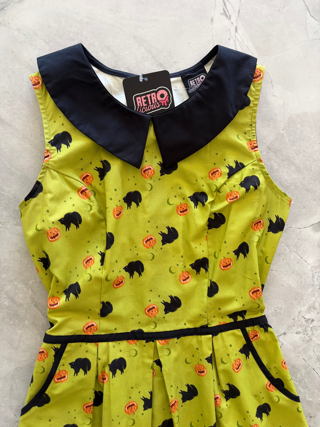 Made in USA. Shop the Black Cat Collared Dress by Retrolicious in 100% cotton, with a Peter Pan collar, contrast piping, A-line skirt and pockets.