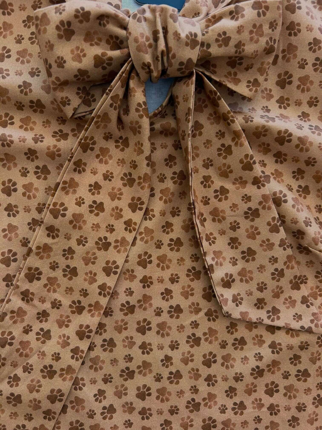 Vintage Style Tops This top is for the vintage lover at heart! Now available in our Paw print. This 100% cotton top features bust darts for a flattering silhouette, a side zippered closure for ease of wear, and an oversized bow at the neckline for that perfect 1950's inspired look.