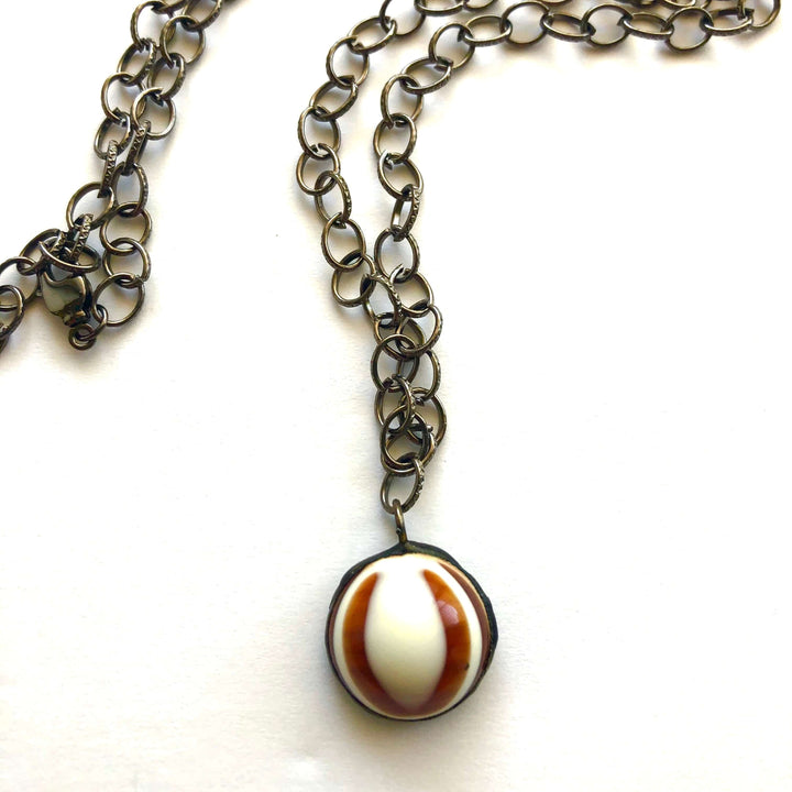 Hand-wrought tortoise bullseye pendant on a 26" hypoallergenic gun metal chain. Limited edition, adjustable, made in USA. Perfect for layering.