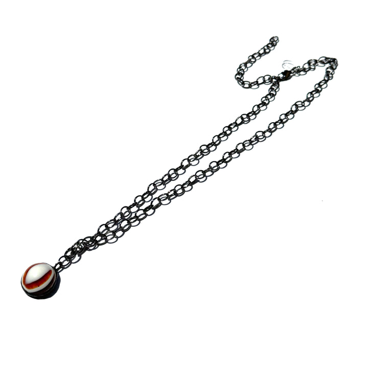 Hand-wrought tortoise bullseye pendant on a 26" hypoallergenic gun metal chain. Limited edition, adjustable, made in USA. Perfect for layering.