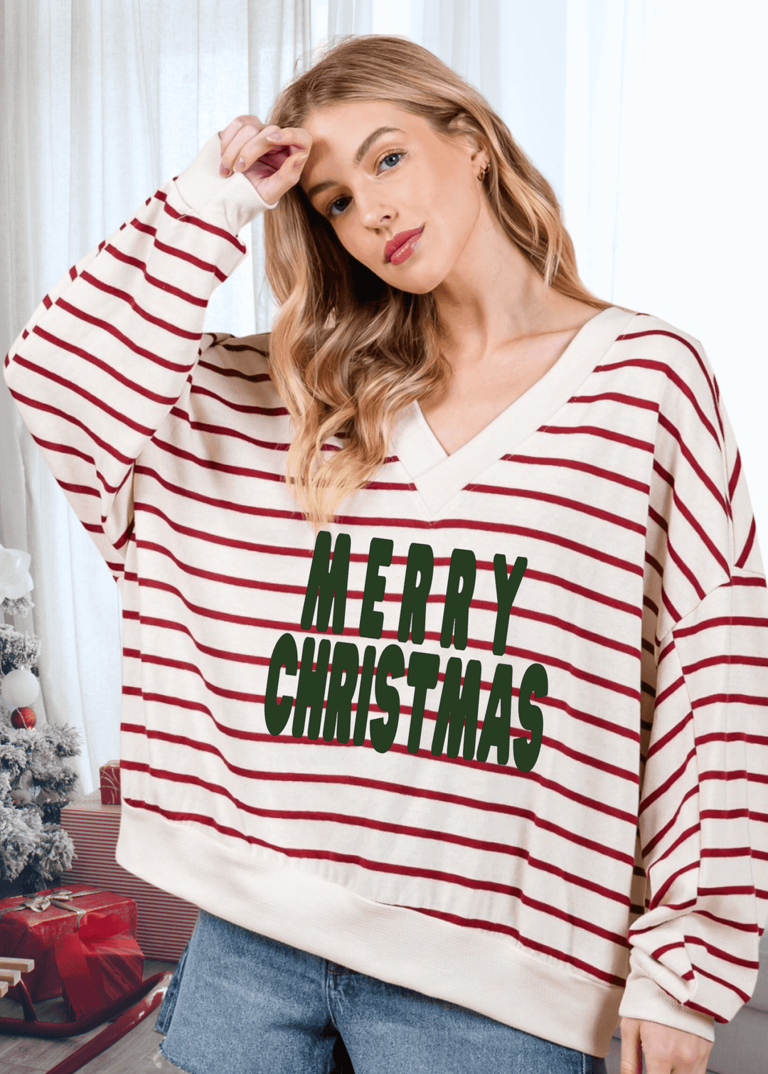 Spread holiday cheer in this oversized sweatshirt featuring a cheerful Merry Christmas graphic against cream and crimson stripes. The double V-neck and drop shoulder design create an effortlessly relaxed silhouette that's perfect for cozy gatherings or casual days at home.  Made in USA