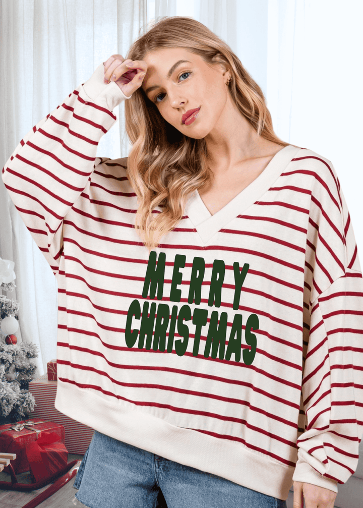 Spread holiday cheer in this oversized sweatshirt featuring a cheerful Merry Christmas graphic against cream and crimson stripes. The double V-neck and drop shoulder design create an effortlessly relaxed silhouette that's perfect for cozy gatherings or casual days at home.  Made in USA